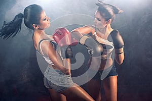 Two athletic girls sparring at gym