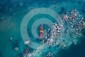 Two athletic man floats on a red boat in river