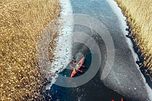 Two athletic man floats on a red boat in river