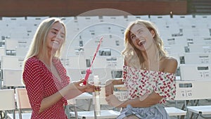 Two attractive beautiful young blond women blow bubbles in the park and are happy on sunset. Girlfriends in park. Slow motion