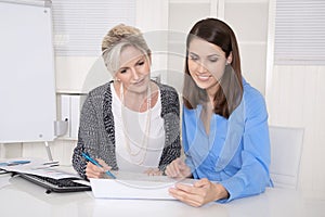 Two attractive businesswoman in meeting analyzing budget.