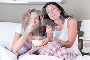 Two attractive women enjoying their women's evening in bed