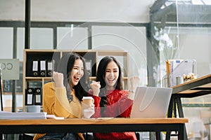 Two Attractive young Asian female college students working on the school project using laptop computer and tablet together, enjoy