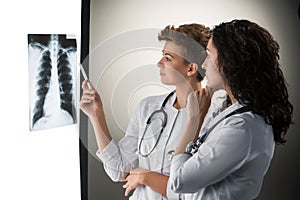 Two attractive young doctors looking at x-ray