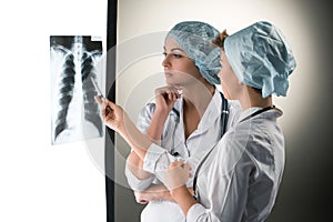 Two attractive young doctors looking at x-ray