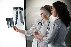 Two attractive young doctors looking at x-ray