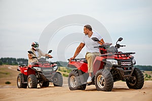 Two atv riders racing in desert sands