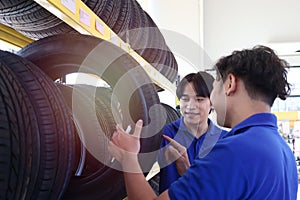 Two auto mechanic checking wheels at vehicle repair service shop, man working in garage, car service technician checking warehouse