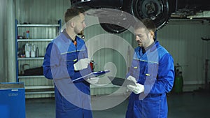 Two auto mechanic diagnose car