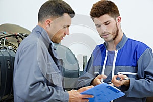 two automobile mechanics checking checklist