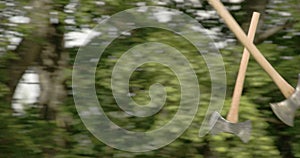 Two axes flying and thrown on the logboard