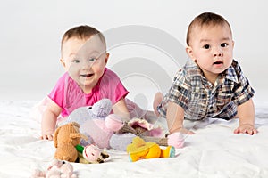 Two babies playing with knitted toys in