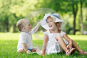 Two babies are sitting on the grass