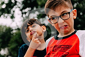 Two baby brothers hug outdoors