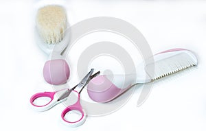 Two baby combs and pink baby scissors