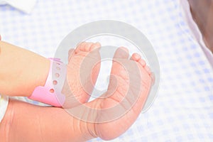 Two baby feet with special tag from maternity hospital photo
