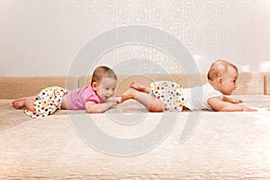 Two baby twins crawling one after another