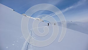 Two backcountry skiers on a climb in the Austrian Alps putting in new tracks on their way to a distant mountain peak