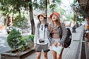 two backpacker girls search for tourist destinations with a road map