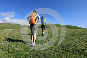 Two backpacking women friends hiking