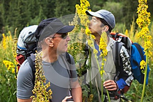 Two backpakers and blooming flowers