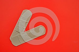 Two bactericidal plasters lie on a red background