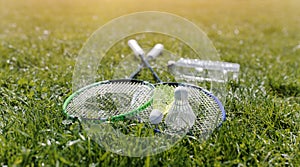 Two badminton rackets and a bottle of water