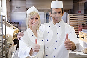 Two bakers showing thumbs up in bakeshop