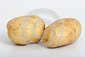 Two baking potatoes isolated on white