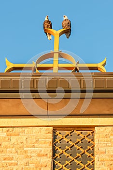 Two bald eagles on Catholic church steeple on top of the Christian cross at Annunciation Church in South Minneapolis