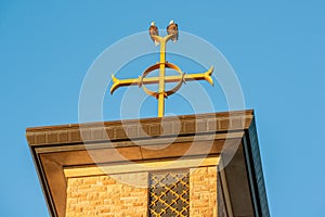 Two bald eagles on Catholic church steeple on top of the Christian cross at Annunciation Church in South Minneapolis