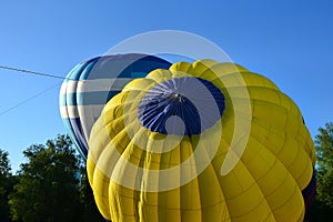 Two balloons before the flight, white-blue and yellow-blue hot air balloon