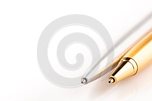 Two ballpoint pens made of steel silver and gold. Objects on a white background