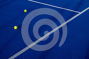 Two balls next to the lines of a paddle tennis court. Wallpaper.