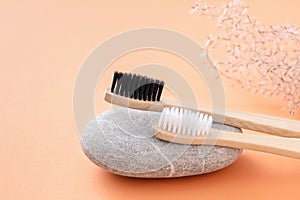 Two bamboo dental brushes on stone. Natural teeth care with wooden toothbrushes