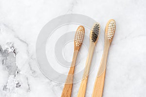 Two bamboo toothbrushes on marble background. Dental and healthcare concept.