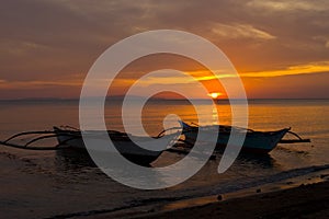 Two Banca Boats at Sunset on Beach photo