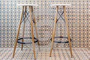 Two bar stools stand against a wall in a cafe