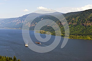 Two barges on the Columbia River with the hilly banks