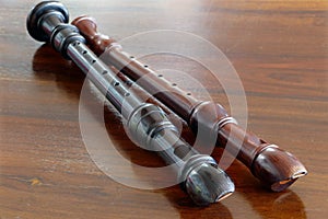 Two baroque recorders, musical instruments, on a wooden table photo
