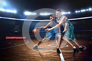 Two basketball players during scrimmage on indoor basketball court photo