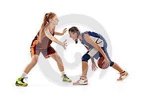 Two basketball players, young girls, teen playing basketball isolated on white background. Concept of sport, team