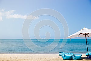 Two beach beds and white umbrella on the tropical beach