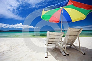 Two beach chairs and colorful umbrella