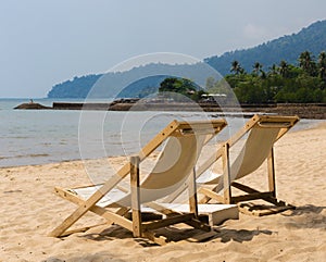 Two beach chairs on idyllic tropical beach.