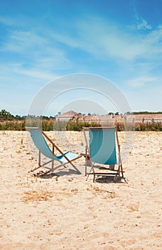 two beach chairs on the sand overlooking rice fields in Comporta Portugal