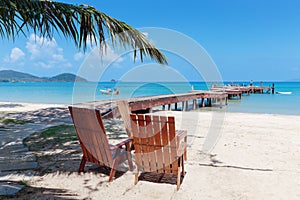 Two beach chairs on tropical sand beach.