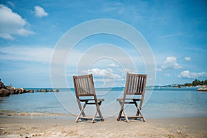 Two beach chairs on tropical shore