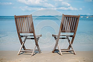 Two beach chairs on tropical shore