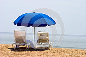 Two beach chairs and umbrella photo